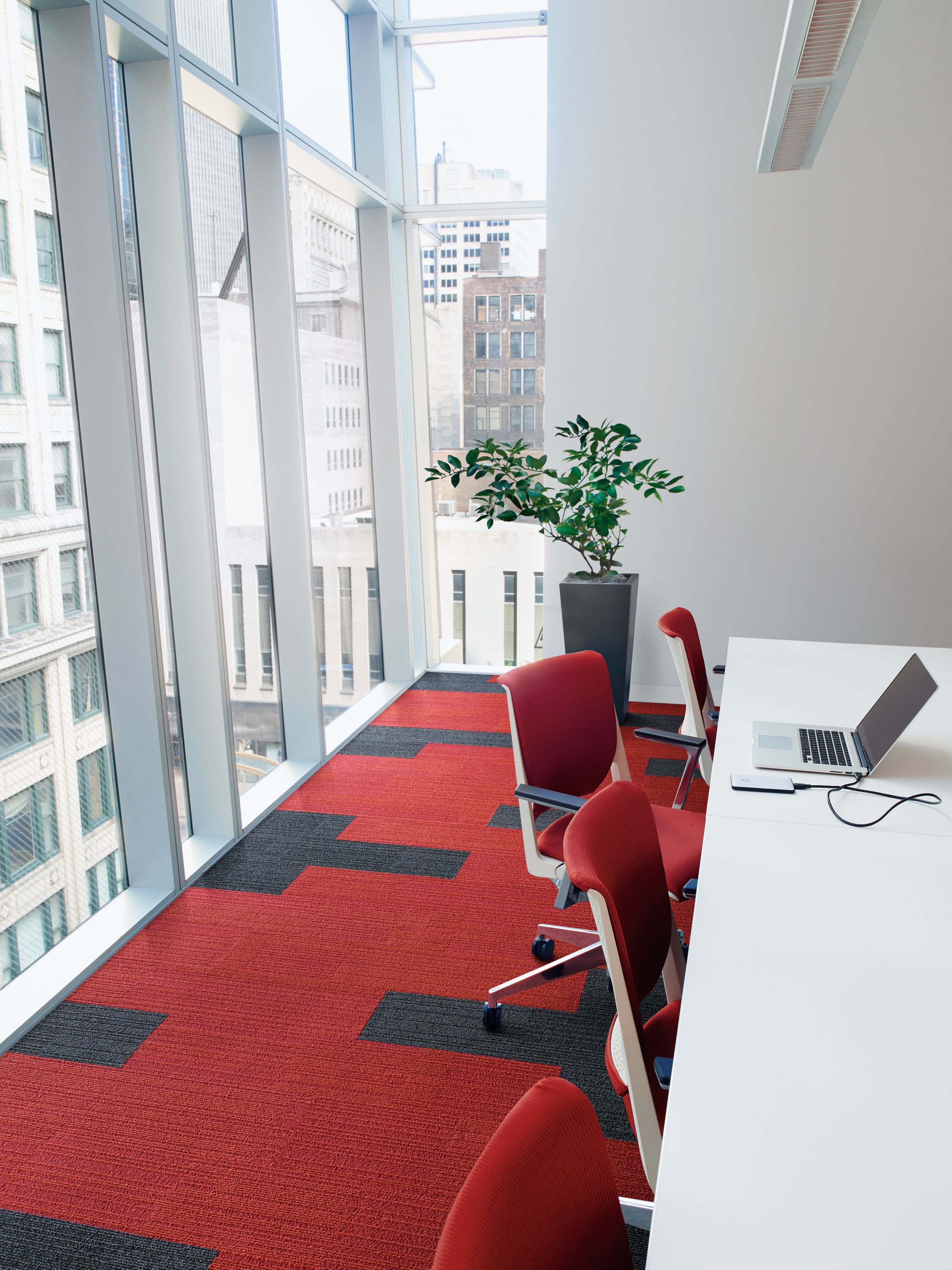 Interface On Line plank carpet tile in corner working space with angled windows overlooking highrise office buildings image number 7